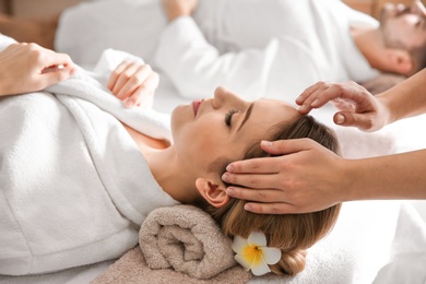 Young woman enjoying head massage in spa salon