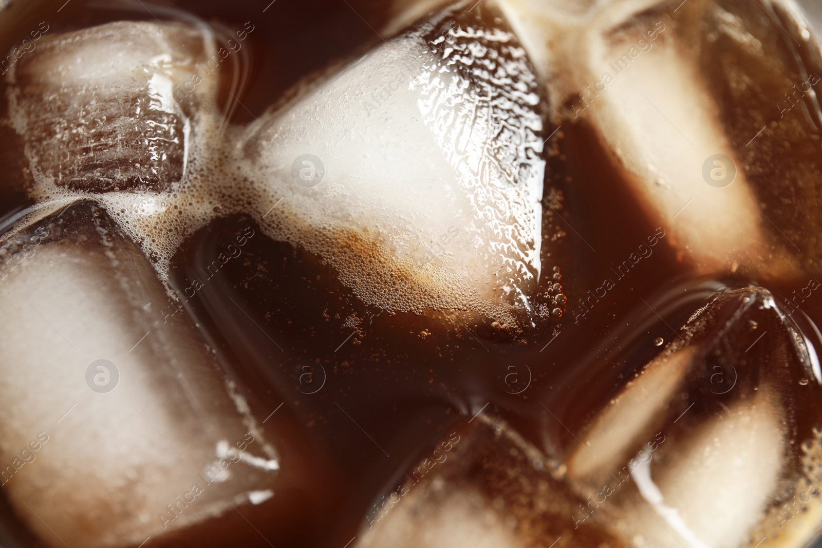 Photo of Tasty coffee drink with ice cubes, closeup