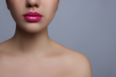 Photo of Closeup view of woman with beautiful full lips on grey background. Space for text