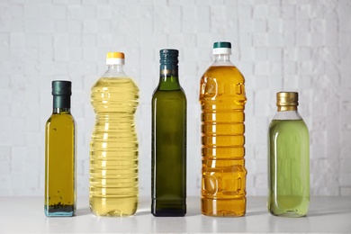 Bottles of oils on table against light background