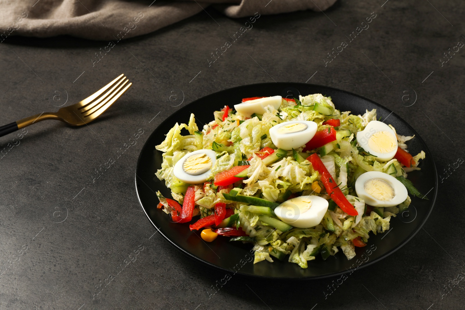 Photo of Delicious salad with Chinese cabbage and quail eggs served on black table