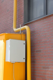 Photo of Gas distribution system with pipe near red brick wall outdoors