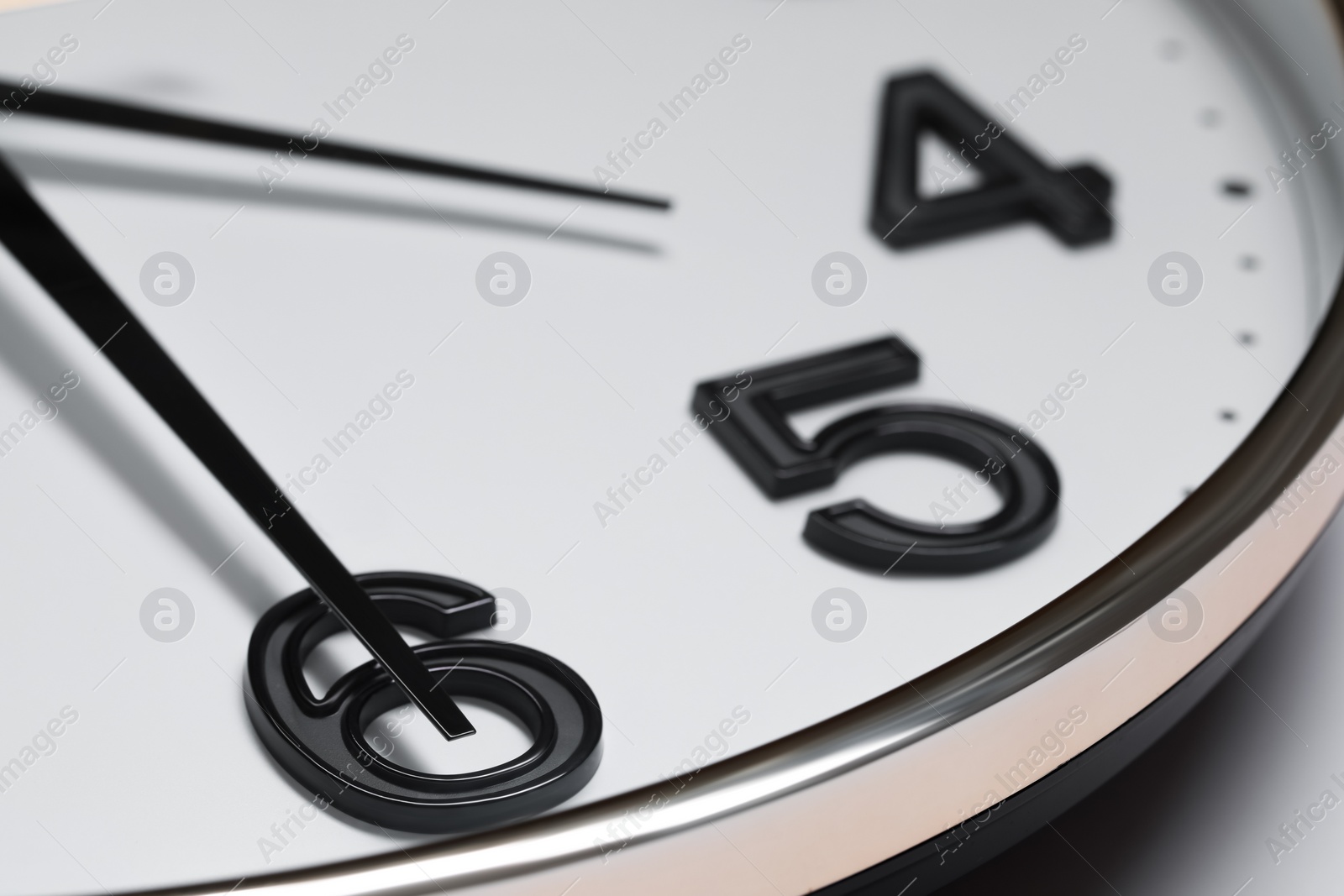 Photo of Stylish round clock on white background, closeup. Interior element