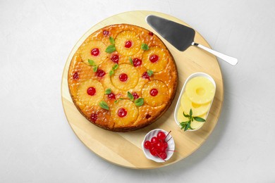 Photo of Tasty pineapple cake and ingredients on white textured table, top view