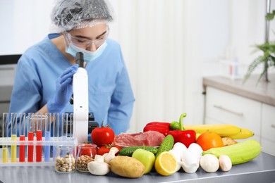 Photo of Scientist checking products at table in laboratory. Quality control