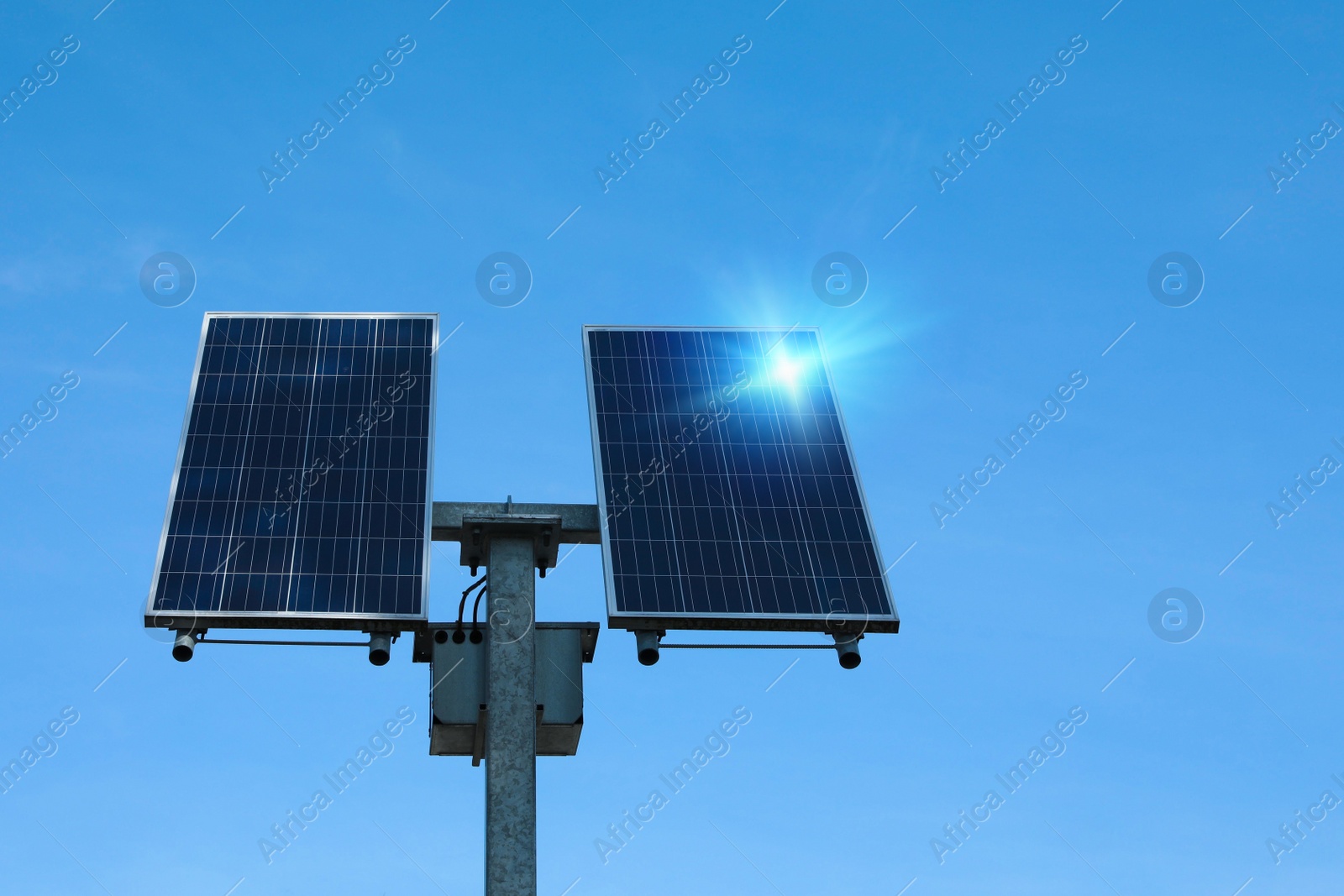 Photo of Modern solar panels against blue sky, low angle view. Alternative energy