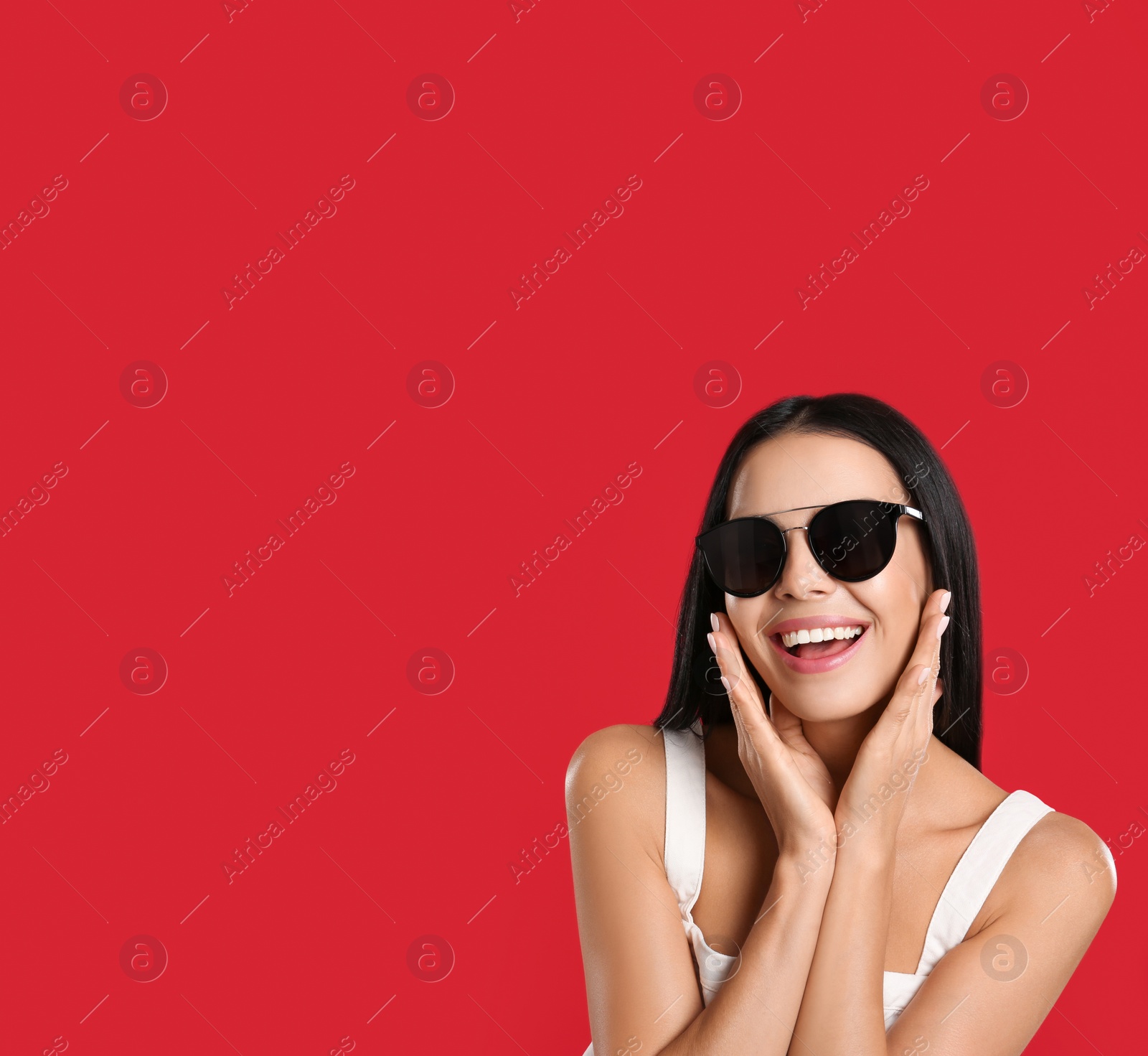 Photo of Beautiful woman wearing sunglasses on red background. Space for text