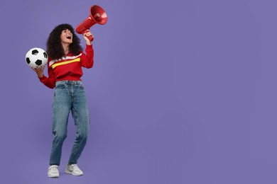Happy fan with soccer ball using megaphone on violet background, space for text
