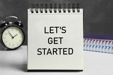 Photo of Notebook with phrase Let's Get Started on white table