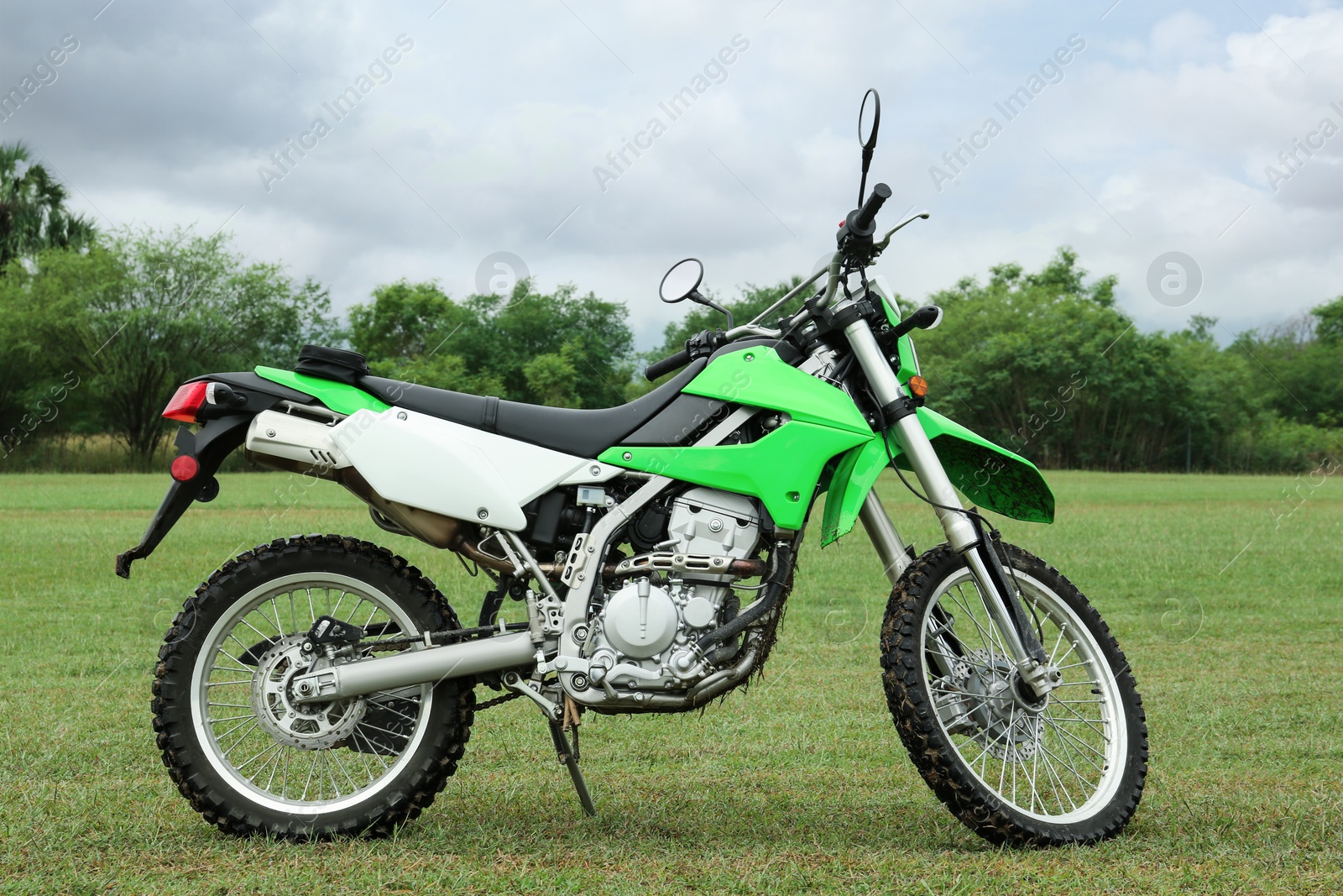 Photo of Stylish cross motorcycle on green grass outdoors