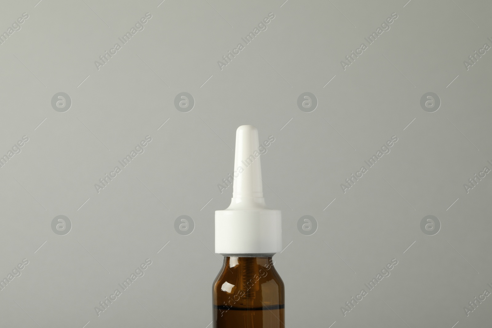 Photo of Bottle of nasal spray on light grey background, closeup