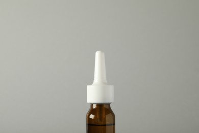Bottle of nasal spray on light grey background, closeup