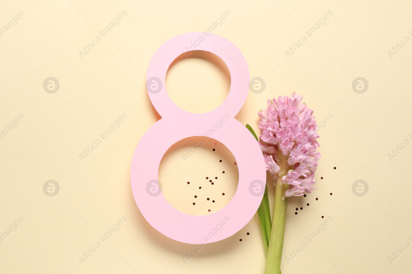 Photo of 8th of March greeting card design with paper number eight and beautiful flowers on beige background, flat lay. International Women's day