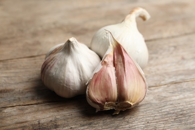 Photo of Fresh organic garlic on wooden table, closeup
