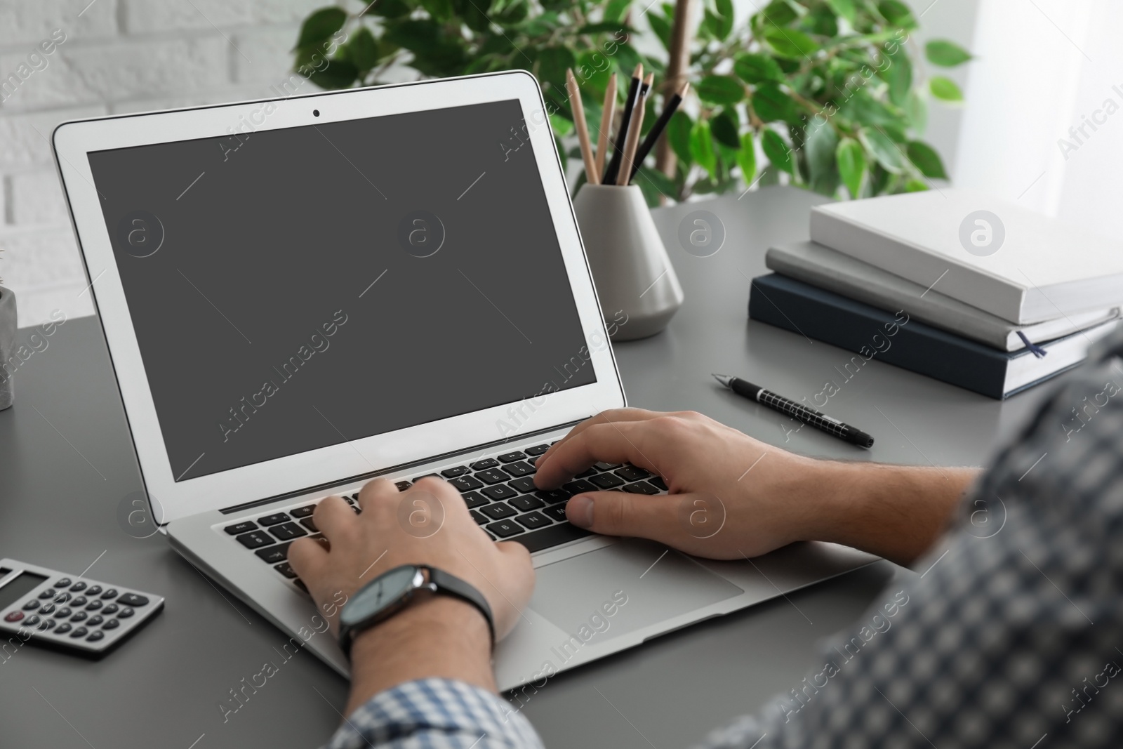 Photo of Man working with laptop at table, closeup. Space for design