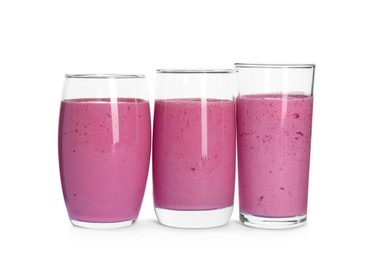 Photo of Glasses of blackberry smoothie on white background