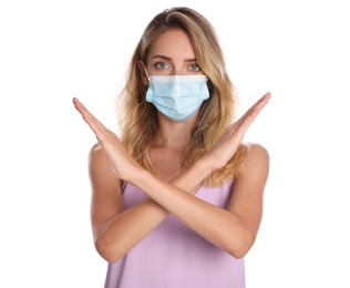 Photo of Woman in protective face mask showing stop gesture on white background. Prevent spreading of coronavirus