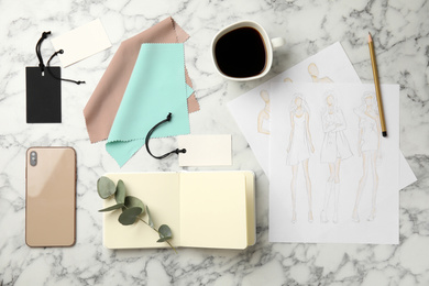 Photo of Flat lay composition with sketches and smartphone on white marble table. Designer's workplace