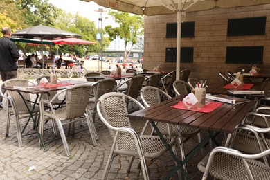 Photo of Cologne, Germany - August 28, 2022: Chairs and tables on terrace near cafe