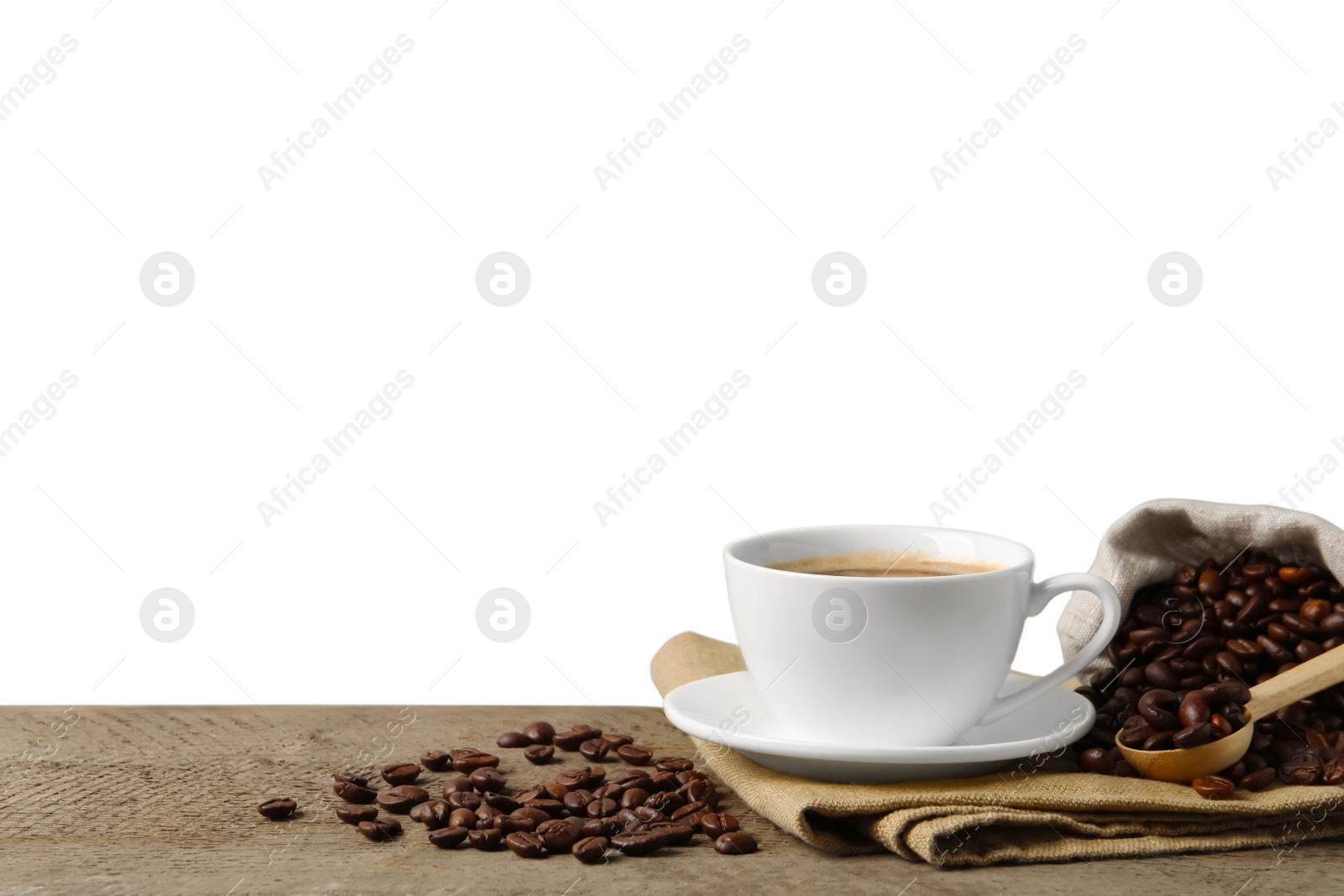 Photo of Cup of aromatic coffee and beans on wooden table against white background