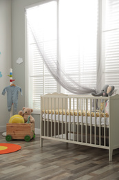 Photo of Stylish baby room interior with crib and toys