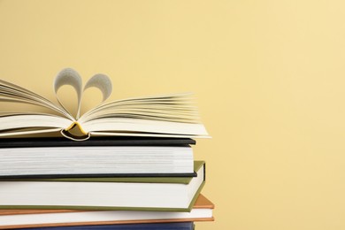 Stack of hardcover books on yellow background, space for text