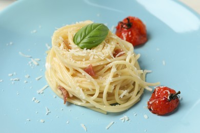 Photo of Tasty spaghetti with tomatoes and cheese on plate, closeup. Exquisite presentation of pasta dish