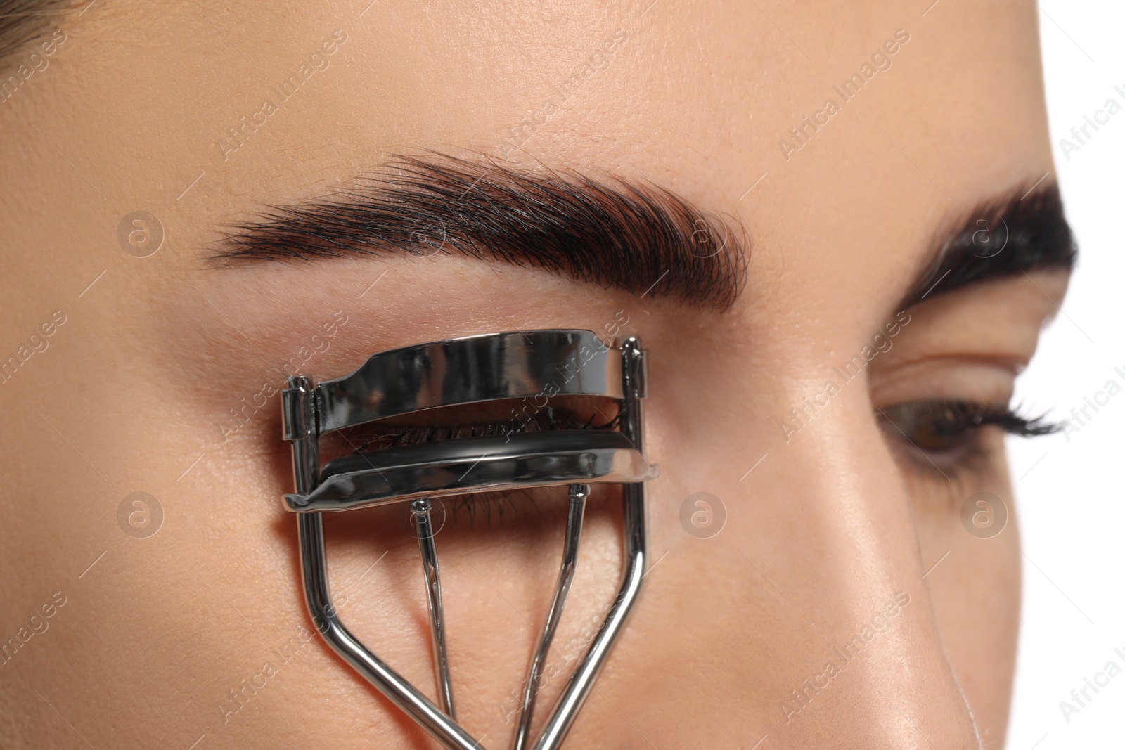 Photo of Woman using eyelash curler on white background, closeup