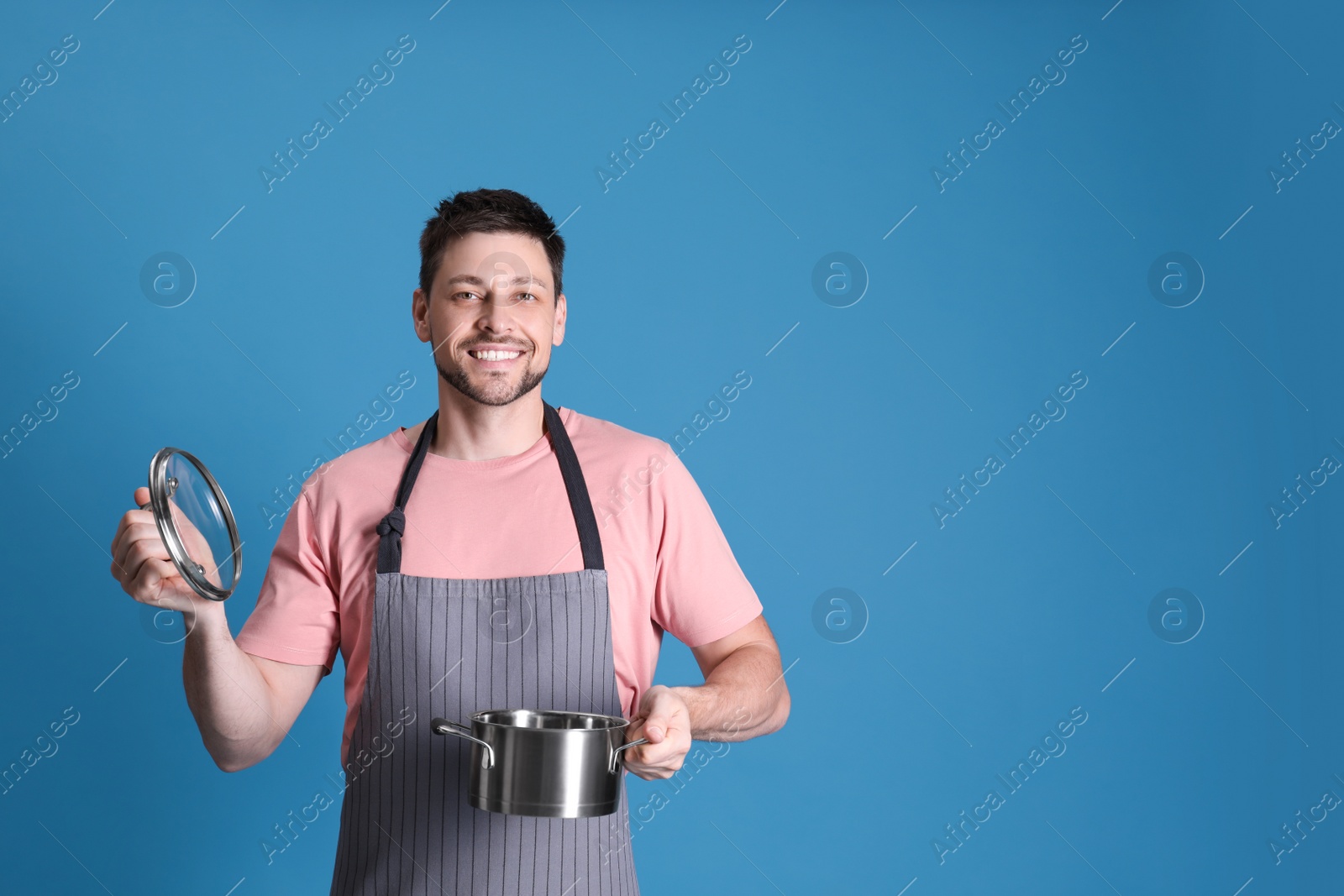 Photo of Happy man with pot on light blue background. Space for text