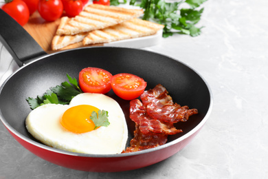 Photo of Tasty breakfast with heart shaped fried egg on grey table