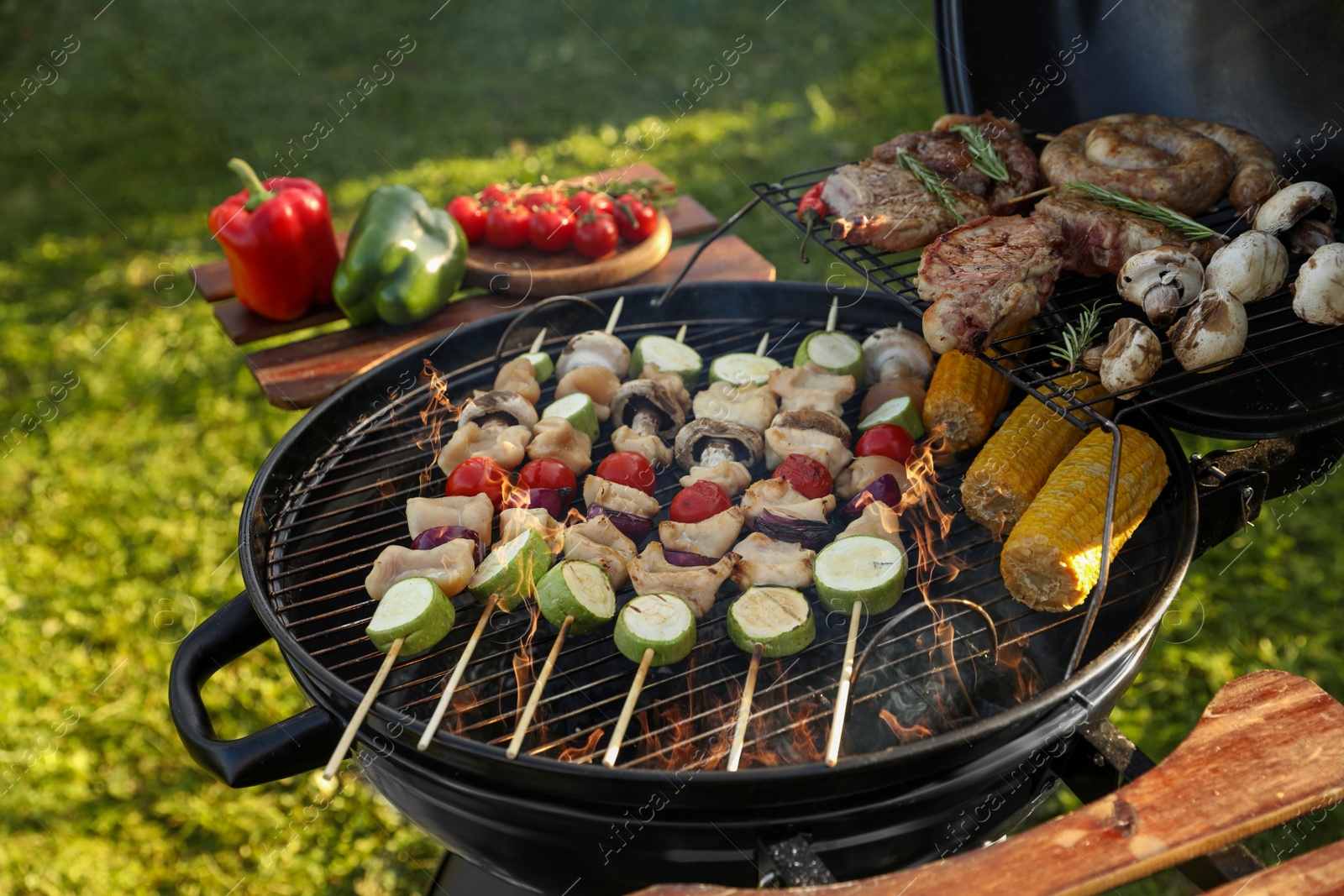 Photo of Cooking meat and vegetables on barbecue grill outdoors