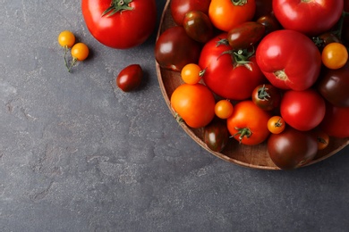 Many fresh ripe tomatoes on grey table, flat lay. Space for text