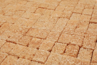 Photo of Brown sugar cubes as background, closeup view