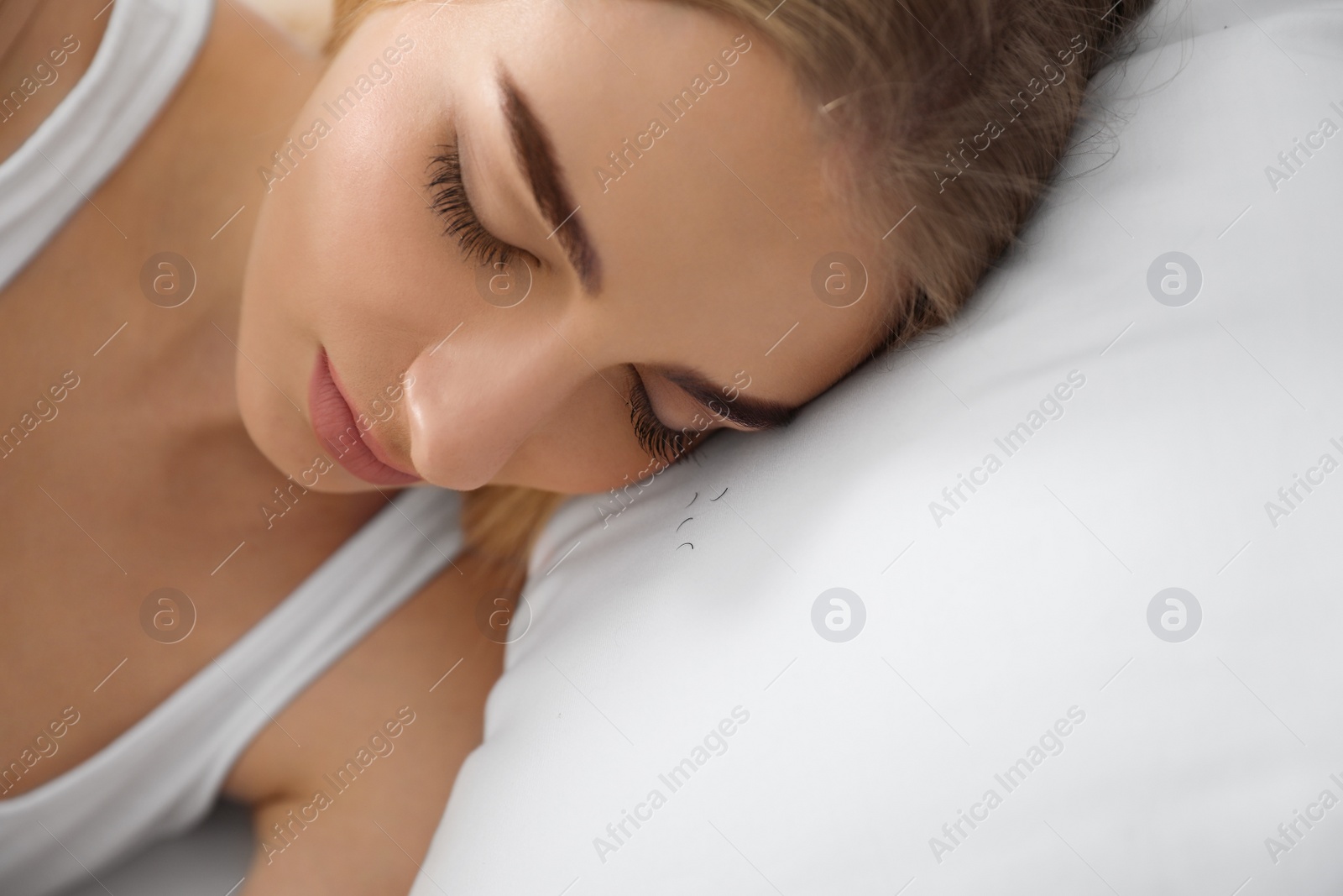 Photo of Sleeping woman and fallen eyelashes on pillow