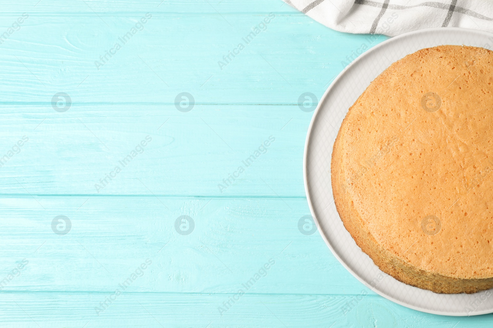 Photo of Delicious fresh homemade cake on light blue wooden table, top view. Space for text