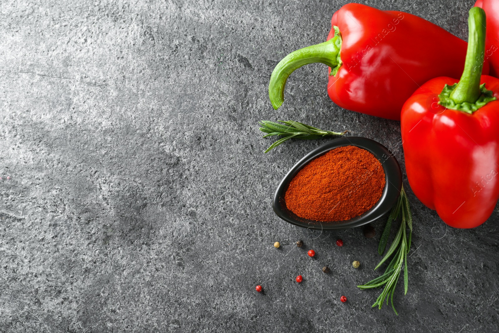 Photo of Dish of paprika with ingredients on grey table, flat lay. Space for text