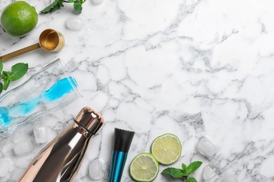Photo of Flat lay composition with ingredients for cocktail and bar equipment on white marble background. Space for text