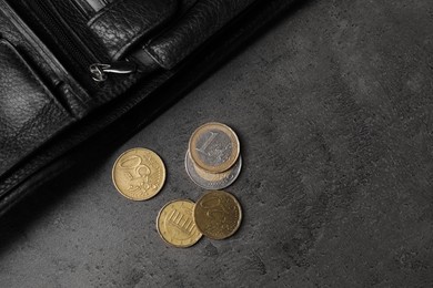 Photo of Poverty. Black wallet and coins on grey table, top view. Space for text