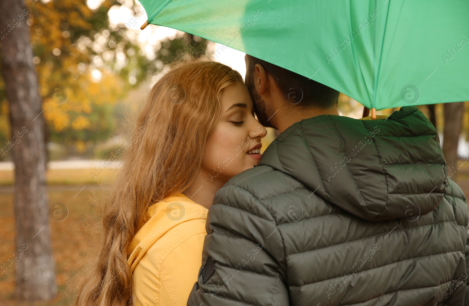 Photo of Happy couple with colorful umbrella in park