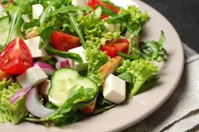 Photo of Delicious salad with meat, arugula and vegetables on plate, closeup