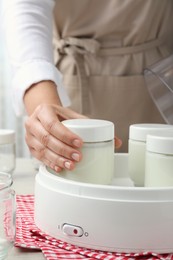 Photo of Woman making tasty yogurt at table, closeup