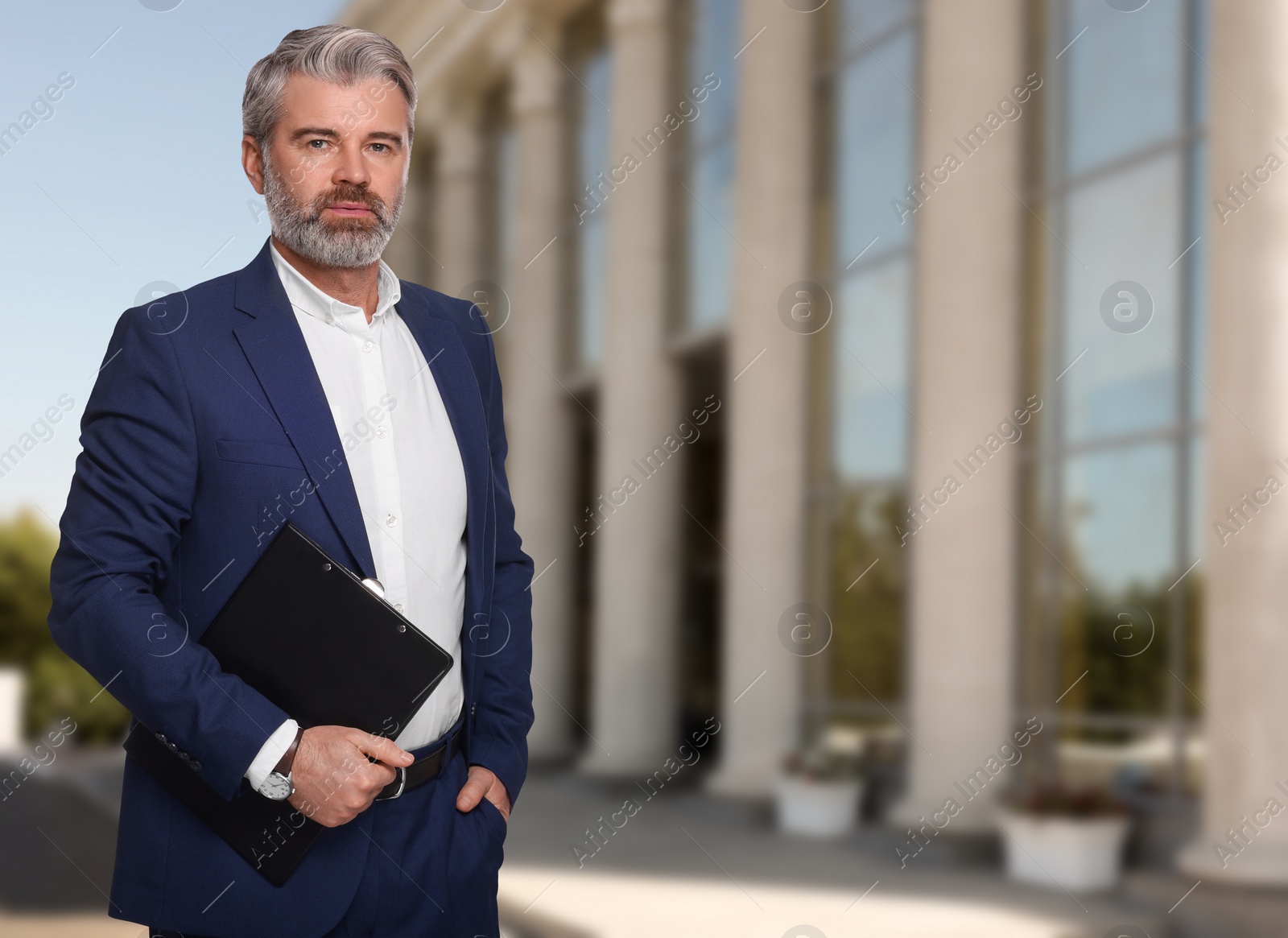 Image of Successful lawyer with clipboard near building outdoors, space for text