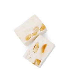 Photo of Pieces of delicious nougat on white background, top view