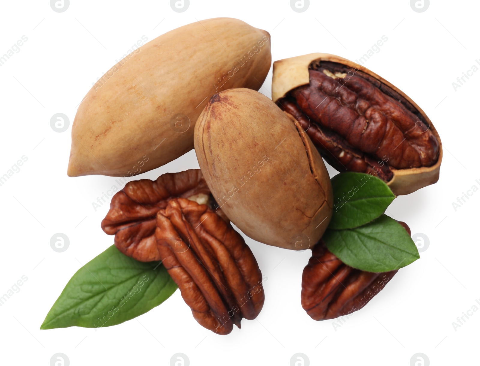 Photo of Many tasty pecan nuts with green leaves isolated on white, top view