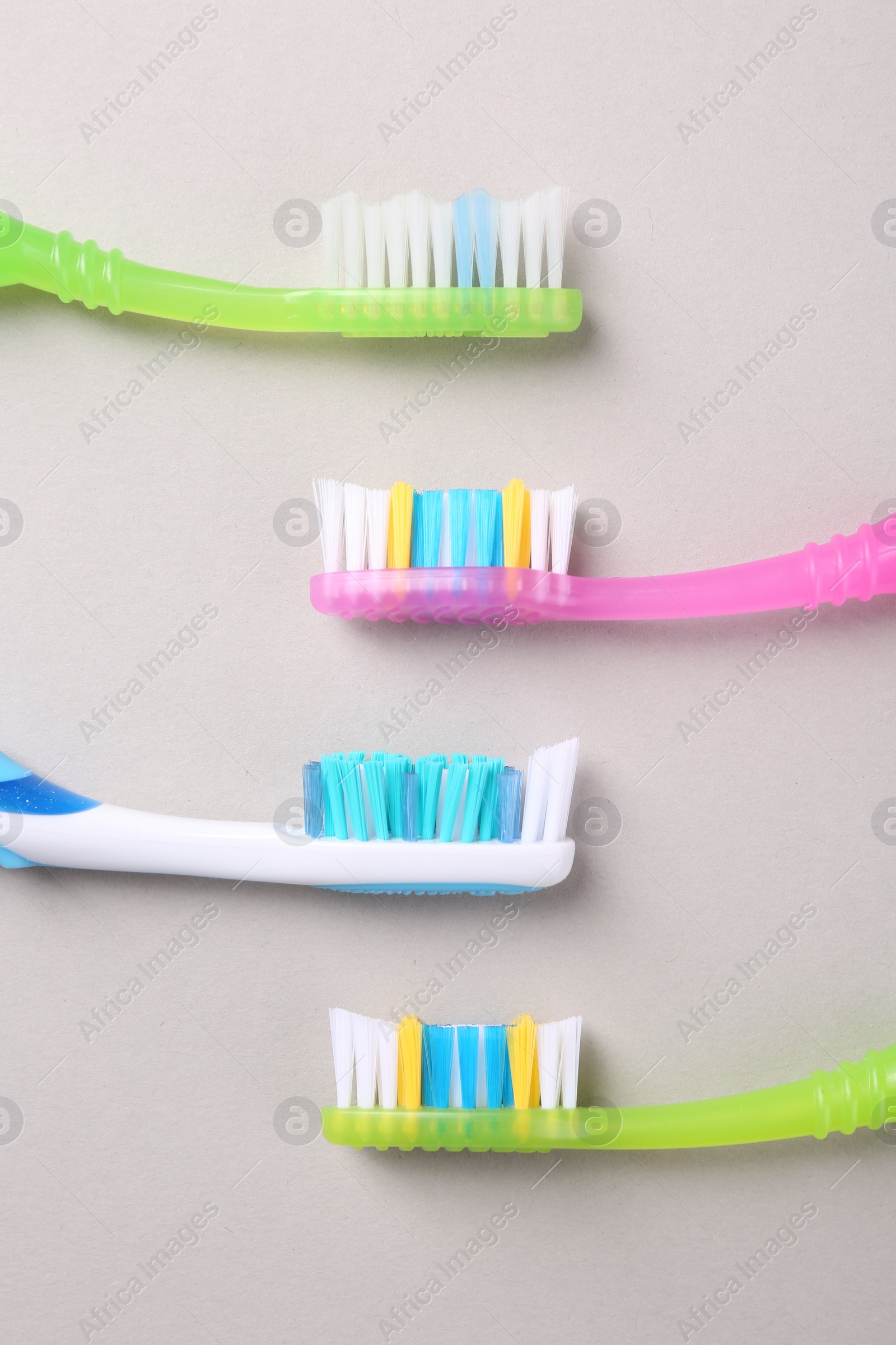 Photo of Many different toothbrushes on light background, flat lay