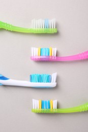 Photo of Many different toothbrushes on light background, flat lay