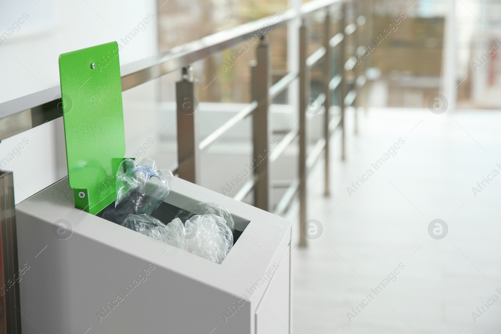 Photo of Metal bin with garbage indoors, space for text. Waste recycling