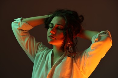 Portrait of beautiful young woman on color background with neon lights