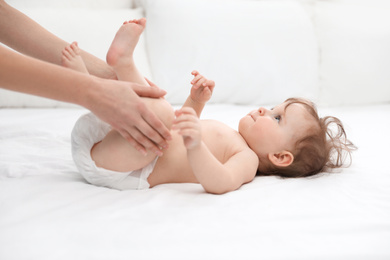 Orthopedist and cute baby on white bed