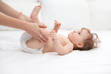 Photo of Orthopedist and cute baby on white bed